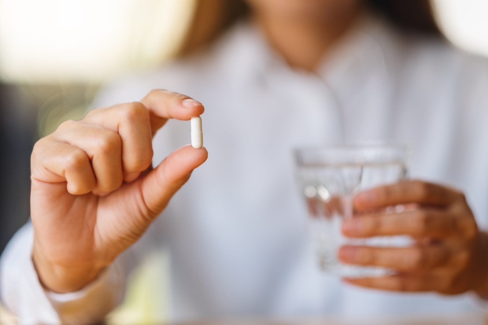 Woman Holding Capsule Water
