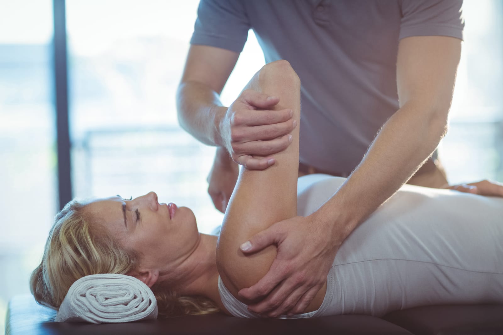 Therapist Stretching Woman Arm Table